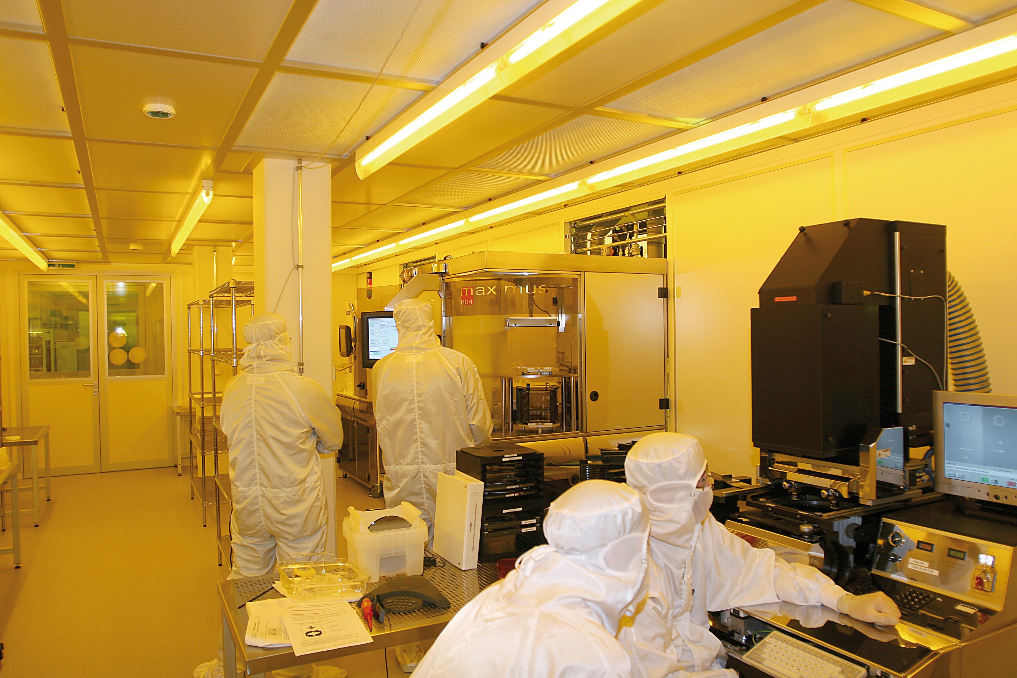 Technicians work in a high-tech cleanroom at Leister’s Swiss facility, manufacturing precision micro-optical components and MEMS gas sensors in controlled conditions.
